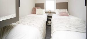 two beds in a small room with a window at 7b Oakwood village in Wilberfoss