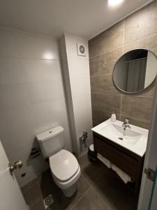 ein Badezimmer mit Toilette, Waschbecken und Spiegel in der Unterkunft A Pasos Tres Cruces in Montevideo