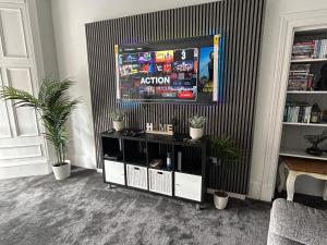 a television in a living room with plants at Sugar boat view in Greenock