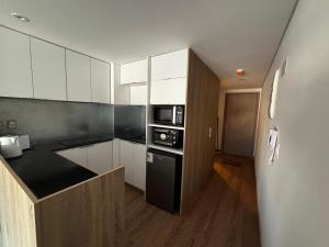 eine Küche mit weißen Schränken und einem schwarzen Kühlschrank in der Unterkunft A Pasos Tres Cruces in Montevideo + 10 Fotos