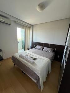 a bedroom with a large bed with white sheets at Flat shopping Ibituruna in Montes Claros