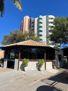 a building with two potted plants in front of a building at Flat shopping Ibituruna in Montes Claros