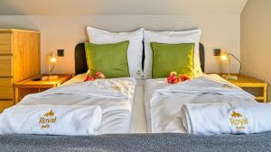 una camera da letto con due letti con lenzuola bianche e cuscini verdi di Dom z sauną w górach Willa Dwa Widoki - by Royal Aparts a Szklarska Poręba