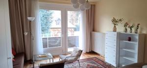 a living room with a chair and a large window at Seenähe - Haus mit Garten in Klagenfurt