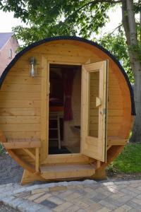 a large wooden dog house with a door in the middle at Campingfass Bunge 1 in Behlitz +6 photos
