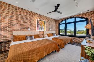 アトランタにあるTop Floor Penthouse Loftsのレンガの壁、ベッド2台が備わるベッドルーム1室が備わります。