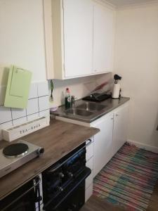 a kitchen with white cabinets and a sink at Molidens Gästgiveri Jönköping in Jönköping +17 photos
