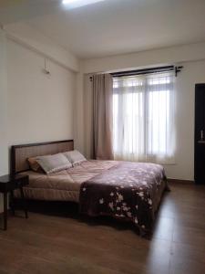 a bedroom with a bed and a large window at Dasukbnb in Shillong +7 photos
