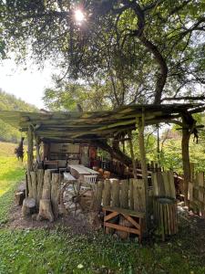 a wooden pavilion with a wagon under a tree at Stillwood Retreat-Off-Grid Nature Escape in Certeju de Jos +11 photos