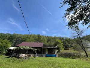 an old house in the middle of a field at Stillwood Retreat-Off-Grid Nature Escape in Certeju de Jos