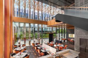 an image of a restaurant with tables and chairs at The Oberoi Gurgaon in Gurgaon