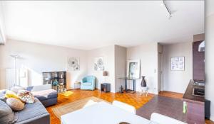 a living room with a couch and a table at GuestReady - Modern chic with a view in La Défense