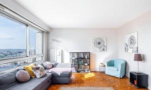 a living room with a couch and a large window at GuestReady - Modern chic with a view in La Défense +6 photos