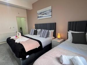 Un dormitorio con dos camas y una lámpara. en Syster Properties Comfortable Leicester Glen Cottage Stay with Free Parking LE3, en Leicester