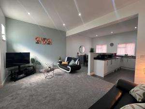 Una sala de estar con un sofá y una cocina. en Syster Properties Comfortable Leicester Glen Cottage Stay with Free Parking LE3, en Leicester