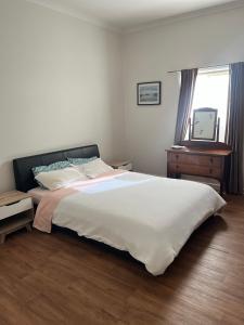 a bedroom with a large white bed and a window at Ocean Road Retreat in Peterborough