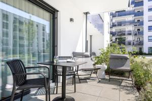 a patio with a table and chairs on a balcony at cruwzo I Regensburg Towers - Design Apartments in Regensburg
