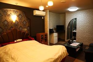 a bedroom with a large bed and a kitchen at ホテルサルビア in Tendo