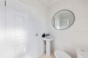 a white bathroom with a sink and a mirror at Modern King Bed WiFi Kitchen Perfect for Long Stay in Gravesend