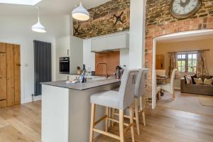 eine Küche und ein Wohnzimmer mit einer Uhr an der Wand in der Unterkunft Carrstone Cottage in Grimston