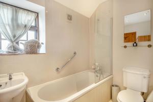 ein Badezimmer mit Badewanne, Toilette und Waschbecken in der Unterkunft Carrstone Cottage in Grimston + 23 Fotos