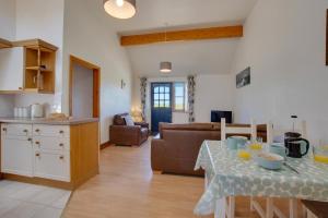 a kitchen and living room with a table and a couch at The Antingham in Roughton +8 photos