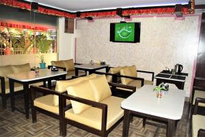 a restaurant with tables and chairs and a tv on the wall at Simple & Sustainable- Room with facilities a guest need in Kathmandu
