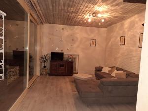 a living room with a couch and a tv at Schöner Bungalow Am Venekotensee in Elmpt