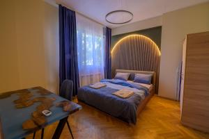 a bedroom with a bed and a table and a window at 1 Minute Walk to Main Street Vitoshka, NDK, Free Parking, 2 BDR in Sofia
