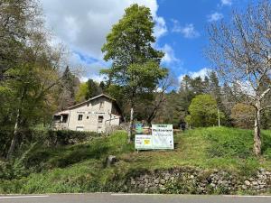 ein altes Haus mit einem Schild davor in der Unterkunft Maison des Cévennes in Arphy