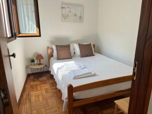 a bedroom with a bed with white sheets on it at Casa Da Laija in Cova