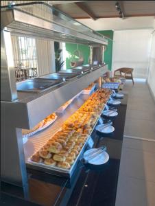 a buffet line of pastries in a restaurant at Vila do Centro Apart Hotel in Bombinhas