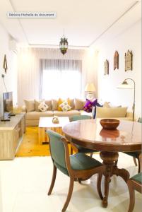 a living room with a table and a couch at Azra Mila Appart luxe famille uniquement in Saidia 