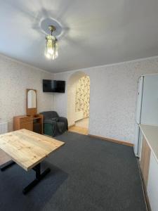 ヴィーンヌィツャにあるCenter apartmentのテーブルと冷蔵庫のあるリビングルーム