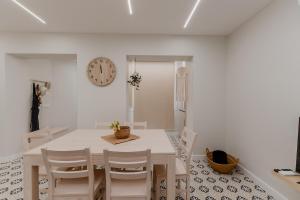 a dining room with a table and chairs and a clock at Newest cozy apartment B in Lisbon