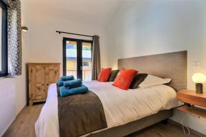 a bedroom with a large bed with red and blue pillows at Chalet D'ardent - Chalet D'Ardent - 8/10 personnes - Montriond MAE-0493 in Montriond