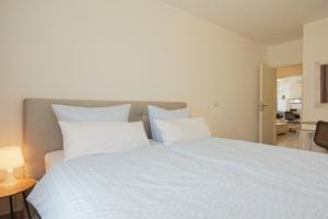 a large bed with white sheets and pillows at Spacious family apartment in Bamberg in Bamberg