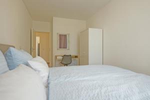 a bedroom with a white bed and a chair at Spacious family apartment in Bamberg in Bamberg