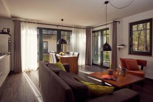 a living room with a couch and a table at Van der Valk Naturresort Drewitz in Nossentiner Hütte