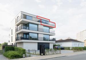 an apartment building with a red roof at Dunique 0302 in Bredene-aan-Zee +2 photos