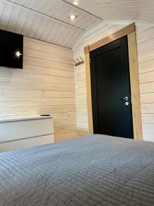 a bedroom with a bed and a black door at Villa Marrikka, Levi in Levi