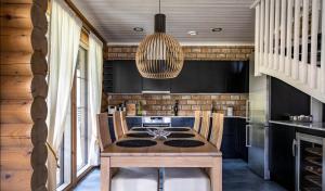 a kitchen with a wooden table and a chandelier at Villa Marrikka, Levi in Levi +15 photos