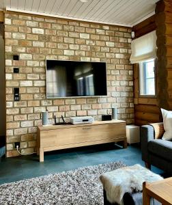 a living room with a tv on a brick wall at Villa Marrikka, Levi in Levi