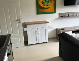 a kitchen with a white cabinet in a room at Ferienwohnung Linus OG 95172 in Rhauderfehn
