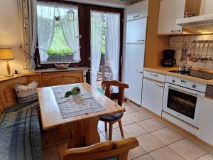 MaisachChristianshof的厨房配有木桌、椅子和炉灶