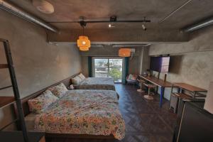 a bedroom with two beds and a table and a desk at シートピア恩納村Ocean 贅沢快適なデザイナーズ空間と蒼い海 in Onna +24 photos