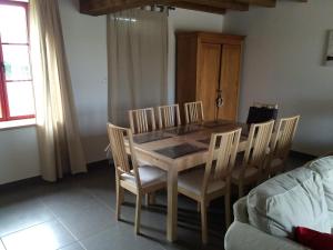 a dining room table and chairs in a room at Gîte les petits cris  +2 photos