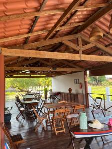 a patio with tables and chairs under a wooden ceiling at Essência de Atins in Atins