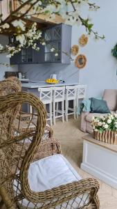 a living room with wicker chairs and a kitchen at DOMKI Nad Jeziorami Niedźwiady in Ślesin
