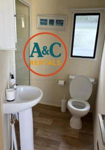 a bathroom with a white toilet and a sink at A&C rentals in Skegness